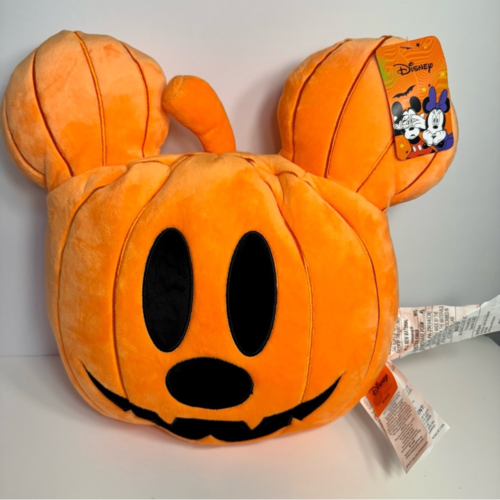 decorative throw pillow in the shape of a Mickey Mouse Pumpkin jack-o'-Lantern.